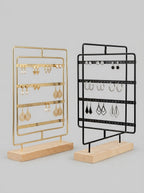 Gold and black metal earring display stands with wooden base